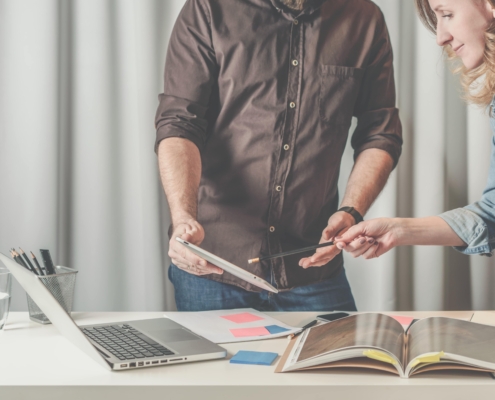 People working on a catalogue with a laptop