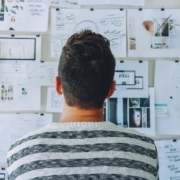 Male looking at diagrams of product features on a wall.