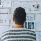 Male looking at diagrams of product features on a wall.