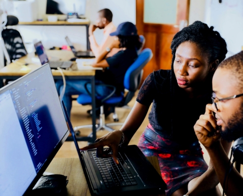 Two work colleagues looking at a computer screen together.