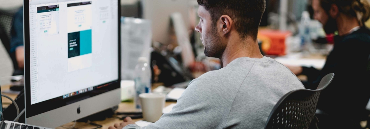 Male at a computer in an office environment.