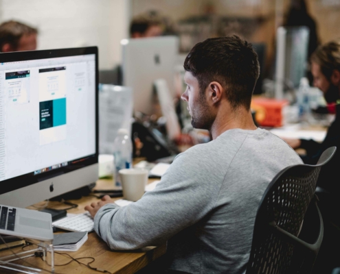 Male at a computer in an office environment.